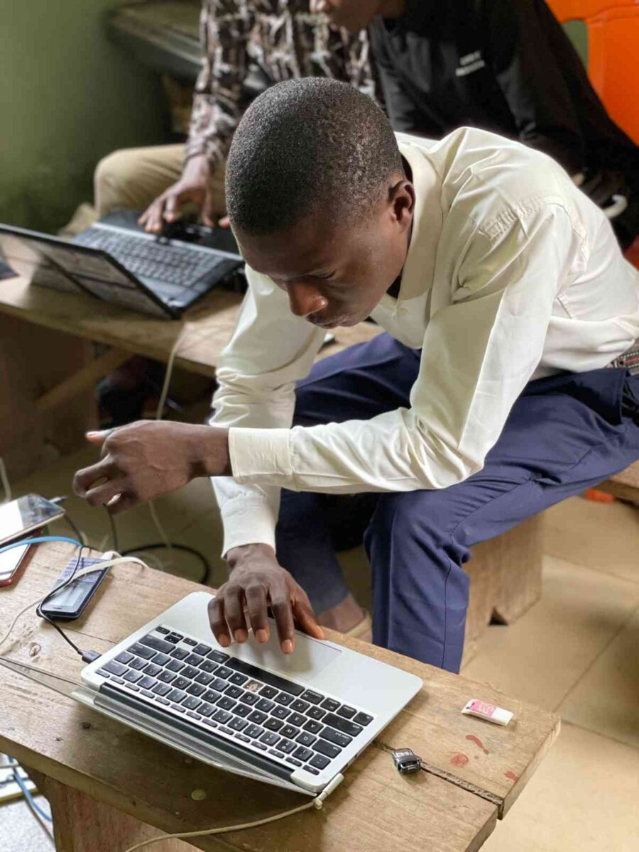  Young Nigerians working on laptops at a community technology hub in a small Nigerian 
town or community centre
